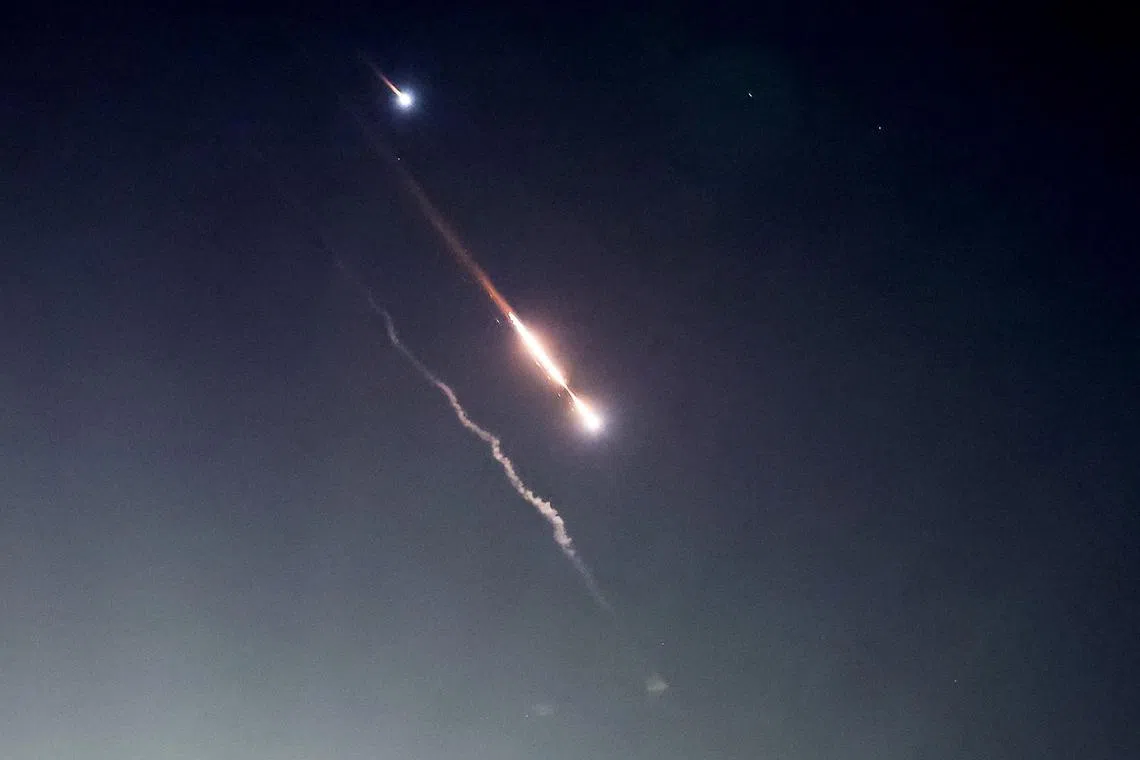 Objects are seen in the sky above Jerusalem on April 14 after Iran launched drones and missiles towards Israel hours earlier.   