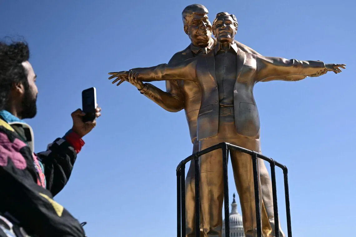 A person taking a picture of a statue of US President Donald Trump and late convicted sex offender Jeffrey Epstein in front of the US Capitol in Washington, DC, on March 10.