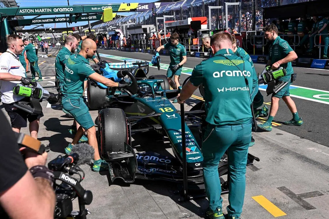 Aston Martin mechanics work on the car of Canadian driver Lance Stroll in the pits during the second practice session of the Australian Grand Prix.