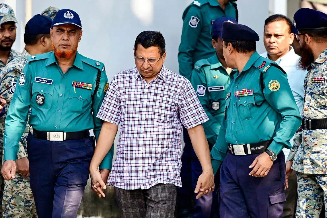 Former police inspector-general Chowdhury Abdullah Al-Mamun (centre) was flanked by serving officers as he was led into court.
