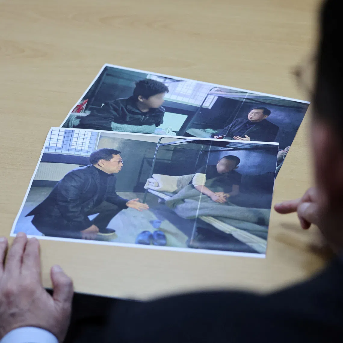 Lawmaker Yu Yong-weon of South Korea’s main opposition People Power Party explains pictures, showing two North Korean POWs who were recently transferred from Ukraine to South Korea, taken during his visit to a POW camp in Ukraine last February, at his office at the National Assembly in Seoul, South Korea, September 28, 2026. Face of POWs are blurred due to security reason by the source. REUTERS/Kim Hong-Ji