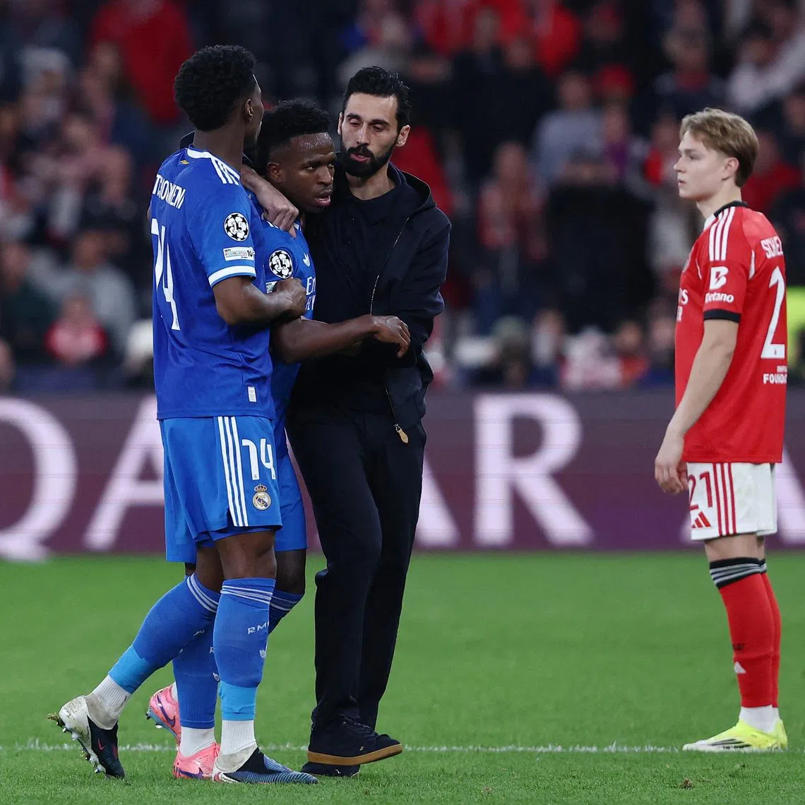 Soccer Football - UEFA Champions League - Play Off - First Leg - Benfica v Real Madrid - Estadio da Luz, Lisbon, Portugal - February 17, 2026 Real Madrid's Vinicius Junior with coach Alvaro Arbeloa and Aurelien Tchouameni as the match was stopped due to racist chants REUTERS/Rodrigo Antunes
