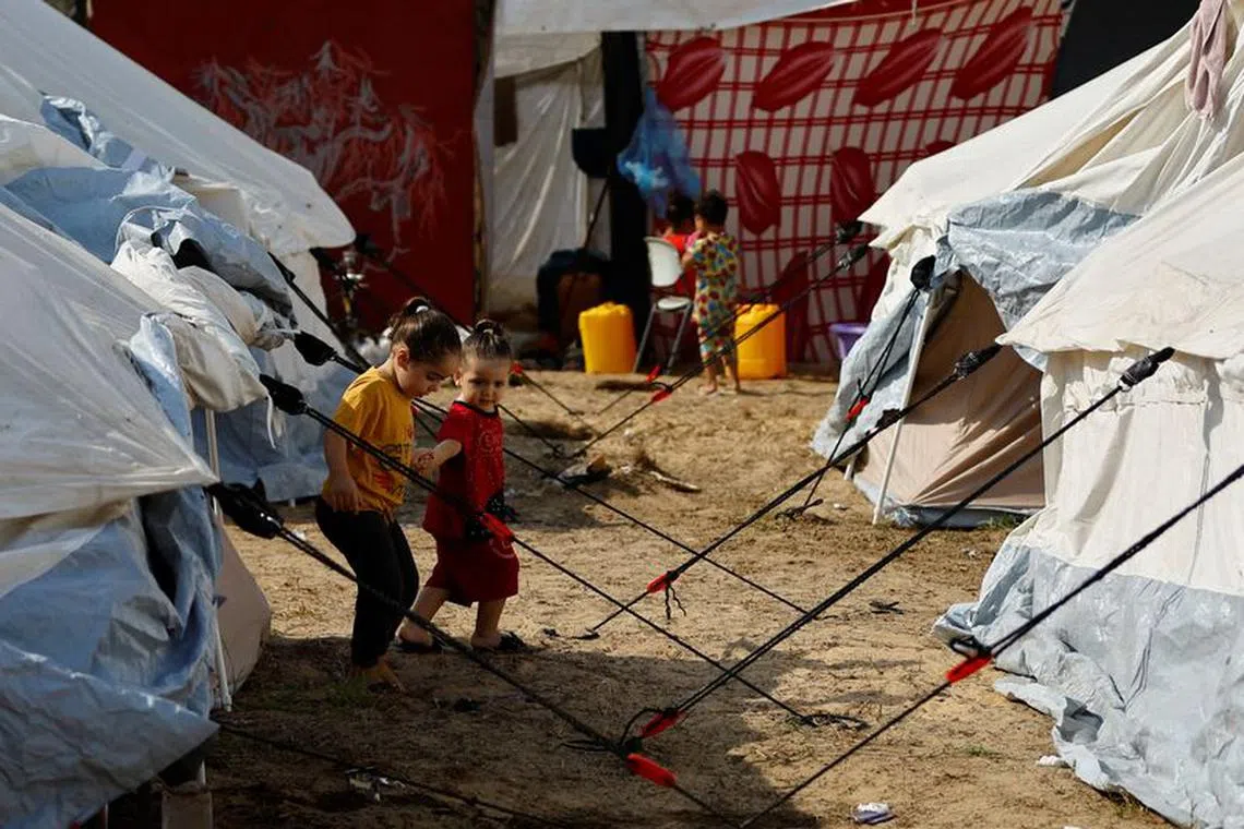 Displaced Palestinian kids, who fled their houses amid Israeli strikes, take shelter in a tent camp at a United Nations-run centre, after Israel's call for more than 1 million civilians in northern Gaza to move south, in Khan Younis in the southern Gaza Strip, October 24, 2023. REUTERS/Ibraheem Abu Mustafa