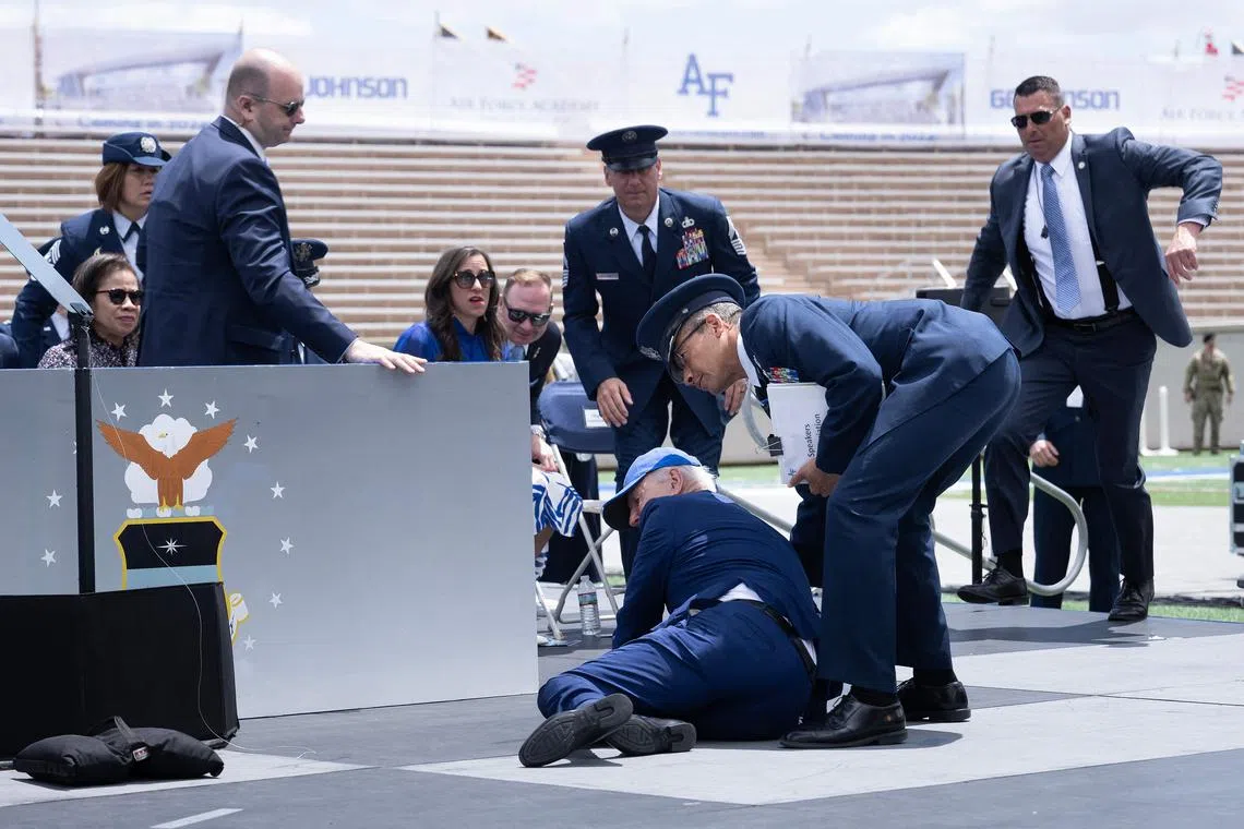 US President Joe Biden is helped up after falling during the graduation ceremony at the United States Air Force Academy, in El Paso County, Colorado, on June 1, 2023. 