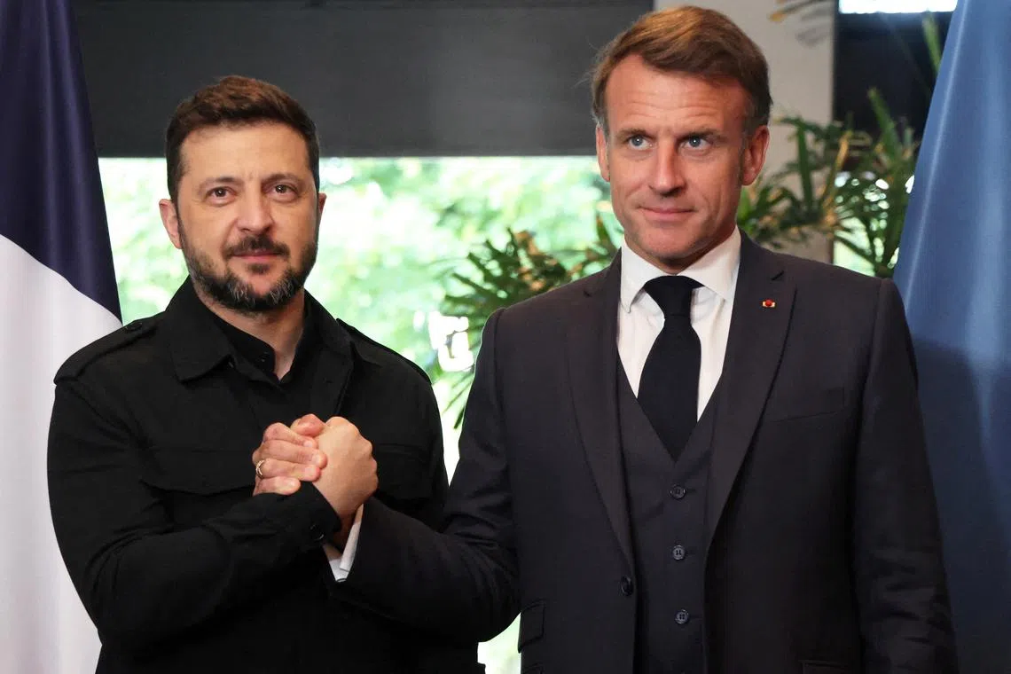 FILE PHOTO: France's President Emmanuel Macron and Ukraine's President Volodymyr Zelenskiy shake hands, as they meet on the sidelines of the two-day NATO's Heads of State and Government summit, in The Hague, Netherlands June 24, 2025. Ludovic Marin/Pool via REUTERS/File Photo