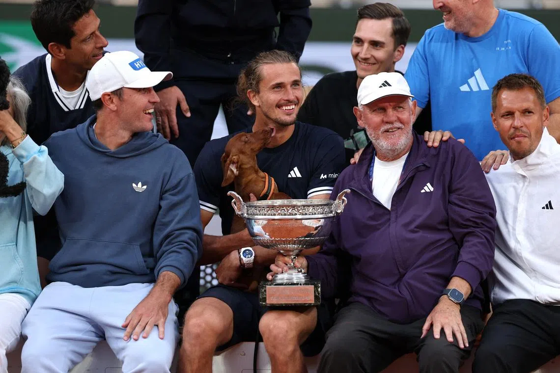 Tennis - French Open - Roland Garros, Paris, France - June 7, 2026 Germany's Alexander Zverev poses for a photograph with the trophy alongside, his brother, Mischa Zverev and dad, Alexander Zverev Sr. as he celebrates winning the final against Italy's Flavio Cobolli REUTERS/Stephane Mahe