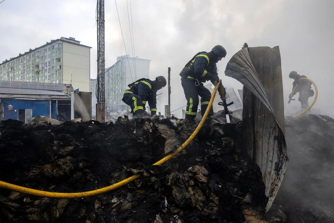 Emergency responders work at the site of a warehouse that was struck during a night of Russian missile and drone strikes, amid Russia's attack on Ukraine, in Novi Petrivtsi, outside Kyiv, Ukraine, December 6, 2025. REUTERS/Thomas Peter
