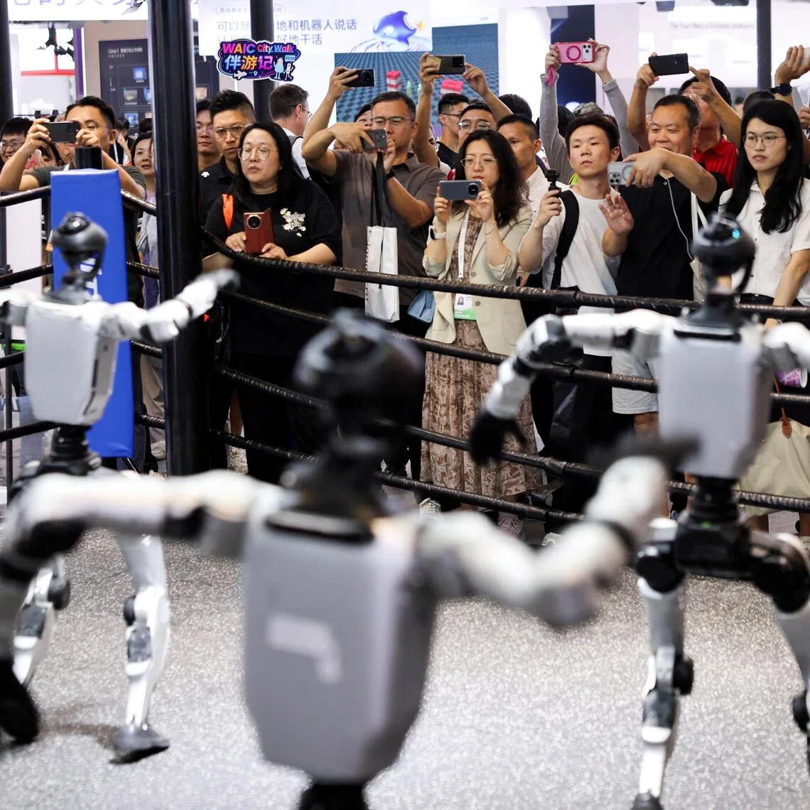 People watch humanoid robots dance at the Unitree booth during the World Artificial Intelligence Conference in Shanghai.