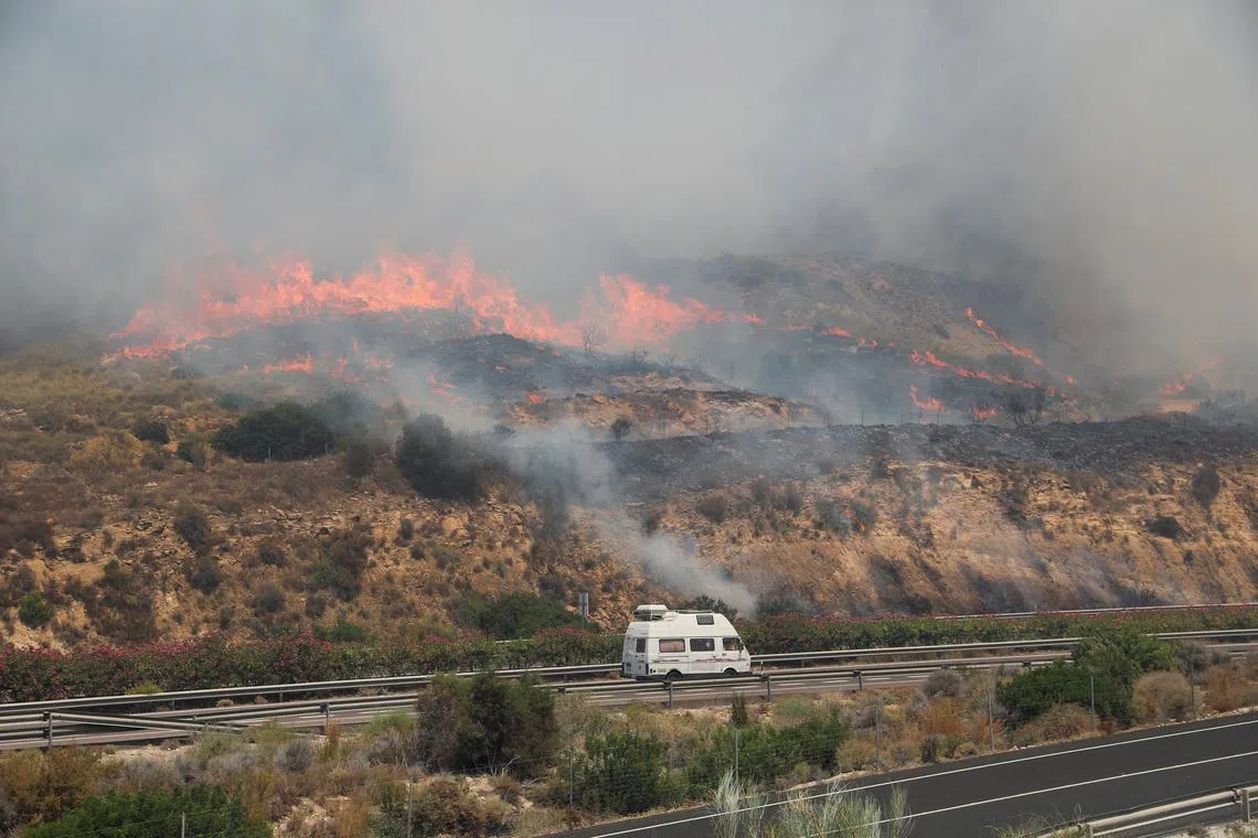A van drives along the A7 highway as a wildfire approaches in the vicinity of Los Gallardos, in Almeria, Spain, on July 10.