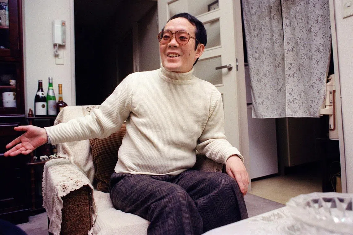 (FILES) This file photo taken on February 5, 1992 shows former Japanese student Issei Sagawa, known as the "Kobe Cannibal" for killing and then devouring a Dutch student in 1981, smiling and gesturing as he meets with an AFP journalist at his apartment in Yokohama. - Sagawa died at the age of 73 on November 24, 2022 his friend and brother said in a statement on December 2. (Photo by JUNJI KUROKAWA / AFP)