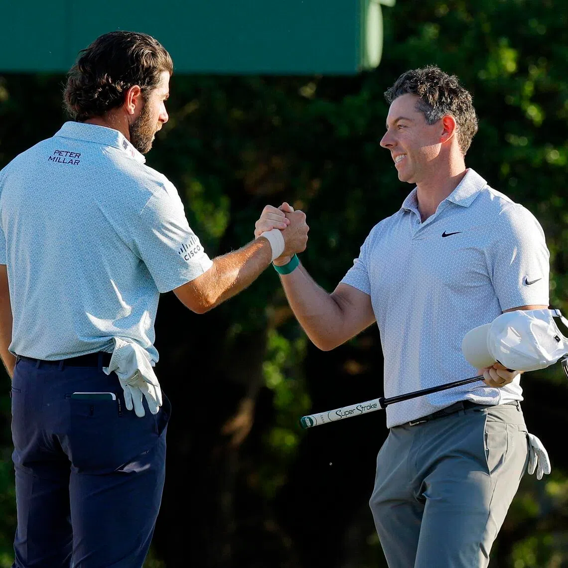 Third-round co-leaders Rory McIlroy of Northern Ireland and Cameron Young of the US shaking hands at Augusta National Golf Club in Augusta, Georgia, on the 18th hole during the second round on April 10.