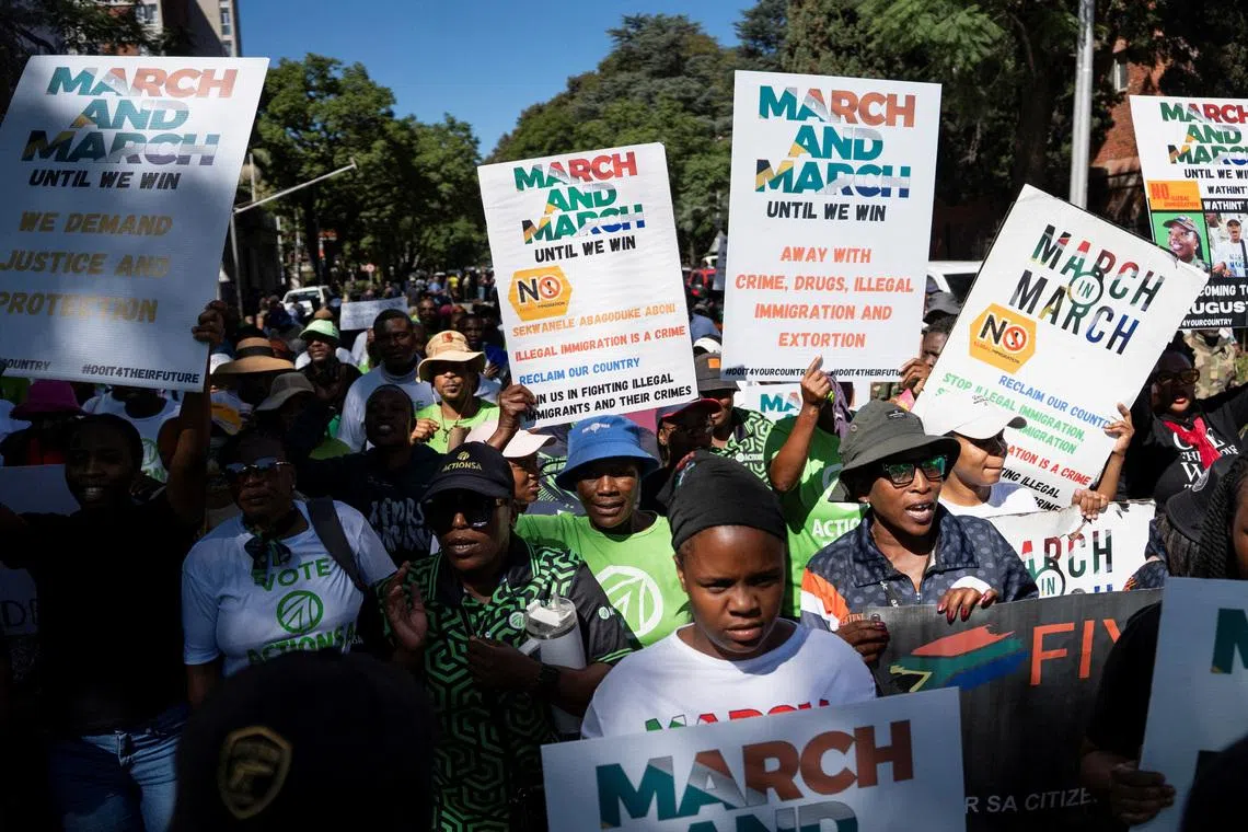 FILE PHOTO: Members of civil society groups and human rights organisations hold placards as they take part in a march calling for stronger government action against illegal immigration in Pretoria, South Africa, April 28, 2026. REUTERS/Ihsaan Haffejee/File Photo
