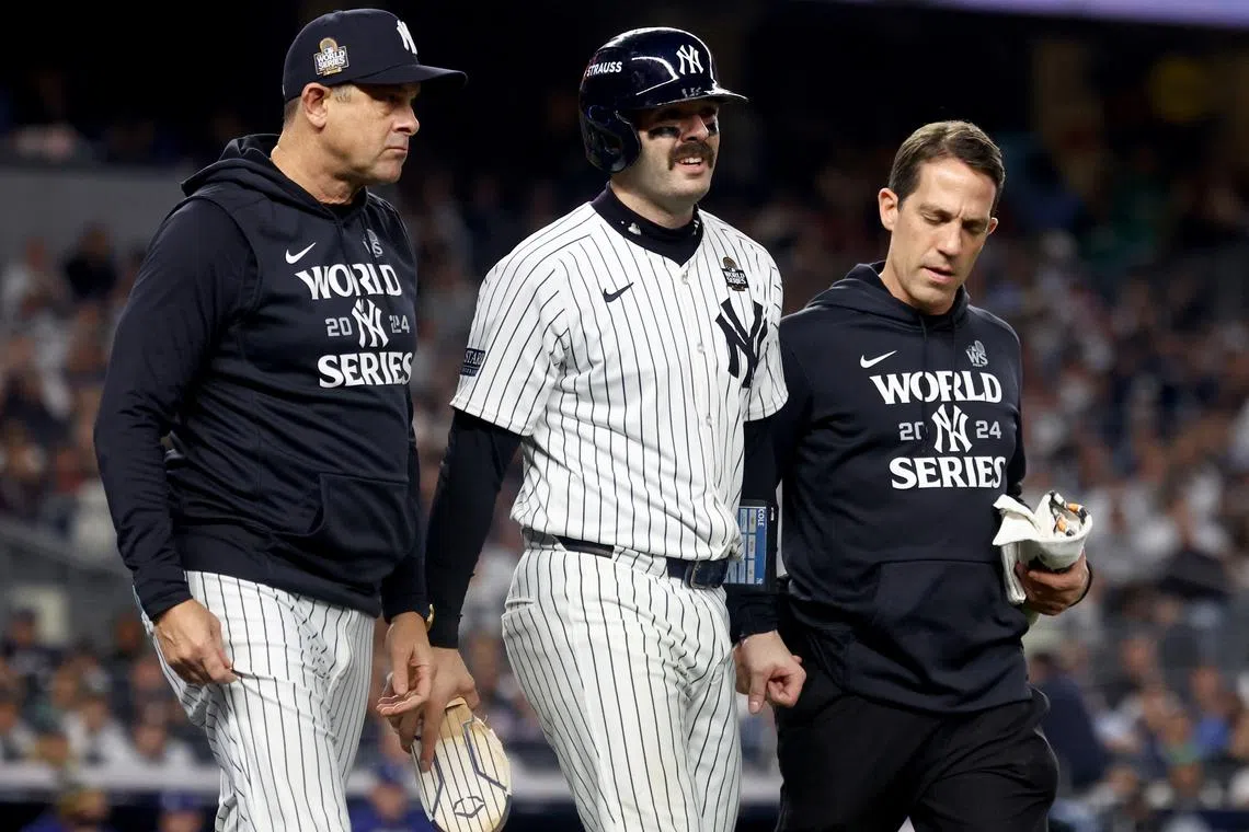 Oct 30, 2024; New York, New York, USA; New York Yankees catcher Austin Wells (28) talks to manager Aaron Boone (17) after being hit by a pitch during the fifth inning against the Los Angeles Dodgers in game five of the 2024 MLB World Series at Yankee Stadium. Mandatory Credit: Vincent Carchietta-Imagn Images