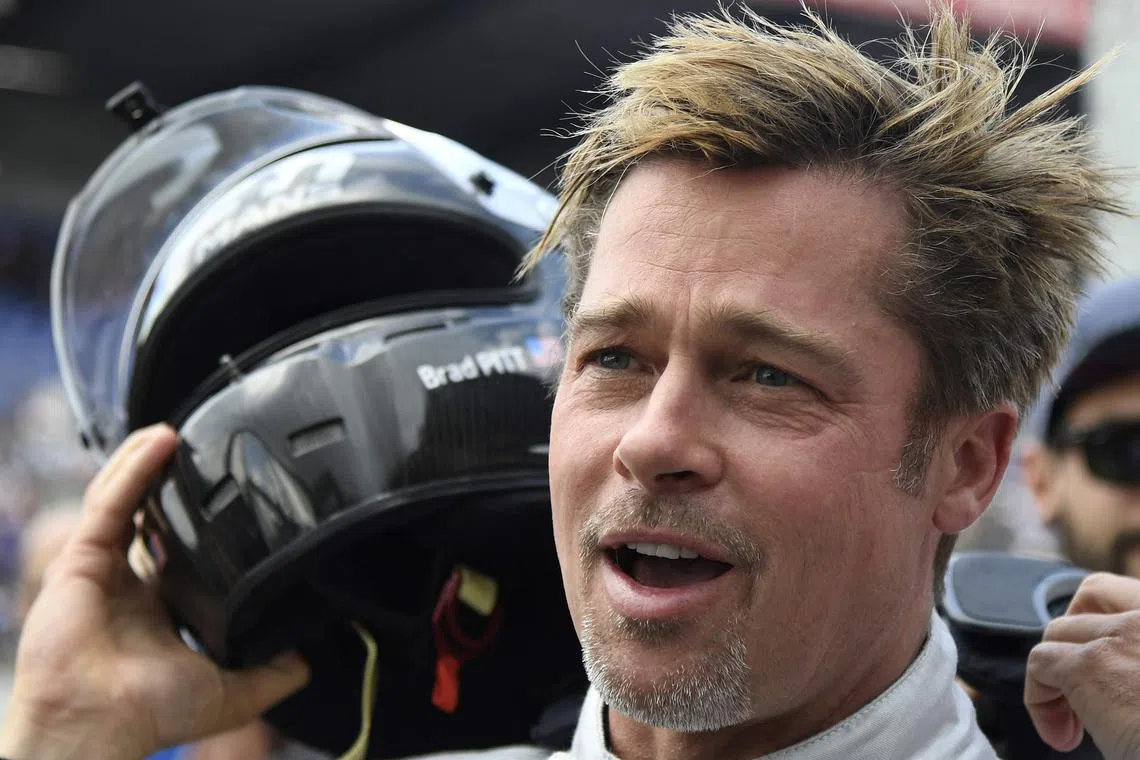 (FILES) US actor Brad Pitt removes his helmet after a full lap on the Le Mans 24 Hours circuit with a Pescarolo Prototype driven by Austria's Alex Wurz, two-time winner and Grand Marshal for the 84th edition of the Le Mans 24 Hours endurance race, on June 18, 2016 in Le Mans, western France. Stars of the cinema and the TV have  been key players in the long and glorious history of the 24 Hours of Le Mans, which celebrates its 100th anniversary on May 26, 2023. (Photo by JEAN-FRANCOIS MONIER / AFP)