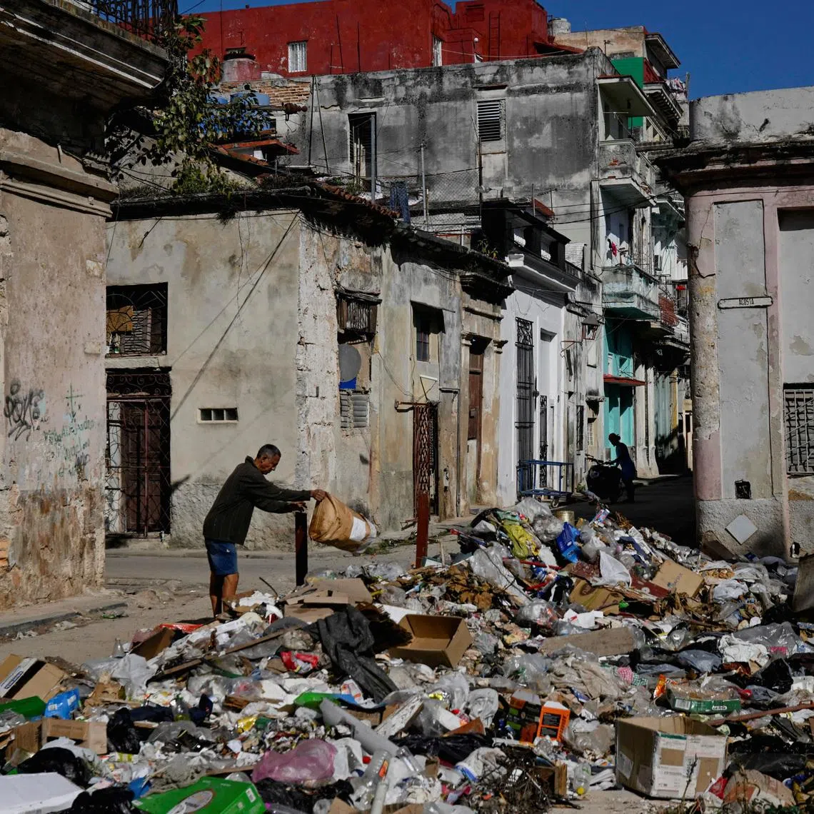 A man throws trash on a street in downtown Havana, Cuba, February 15, 2026. REUTERS/Norlys Perez