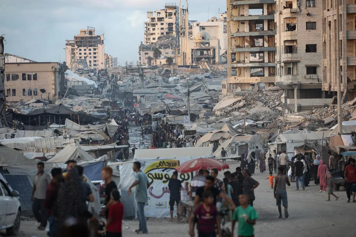 Displaced Palestinians from the northern Gaza Strip flee with their belongings to a displacement camp along Al-Rasheed Street, west of Gaza City.