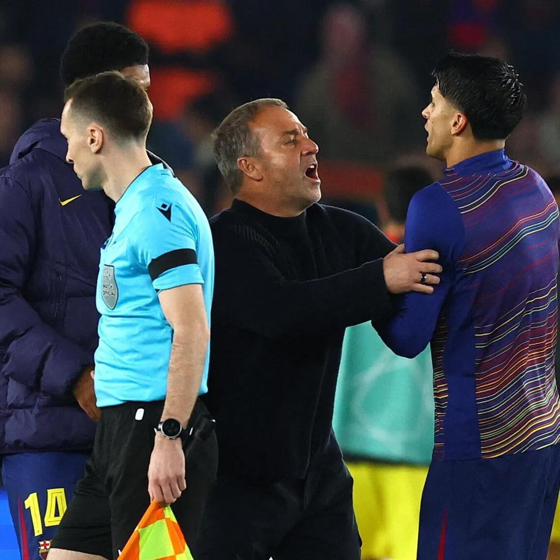 Barcelona coach Hansi Flick pushing away Joao Cancelo from the match officials after the 2-0 home Champions League quarter-final, first-leg defeat by Atletico Madrid at the Camp Nou on April 8, 2026.