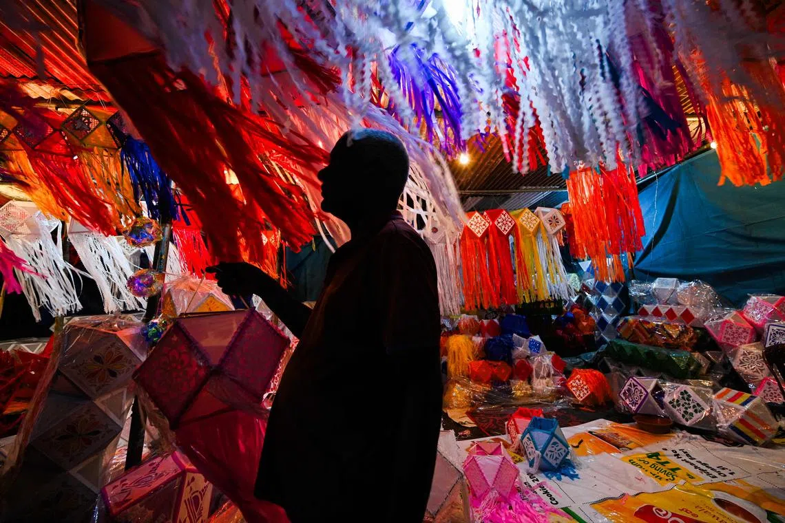 A vendor arranging paper lanterns at his roadside shop ahead of 'Vesak' festival, to commemorate the birth, enlightenment and death of Buddha, in Colombo, on May 20, 2024. 