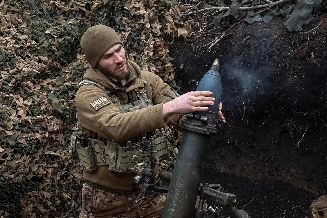 A Ukrainian serviceman fires a 120mm mortar towards Russian troops, near the town of Bakhmut.
