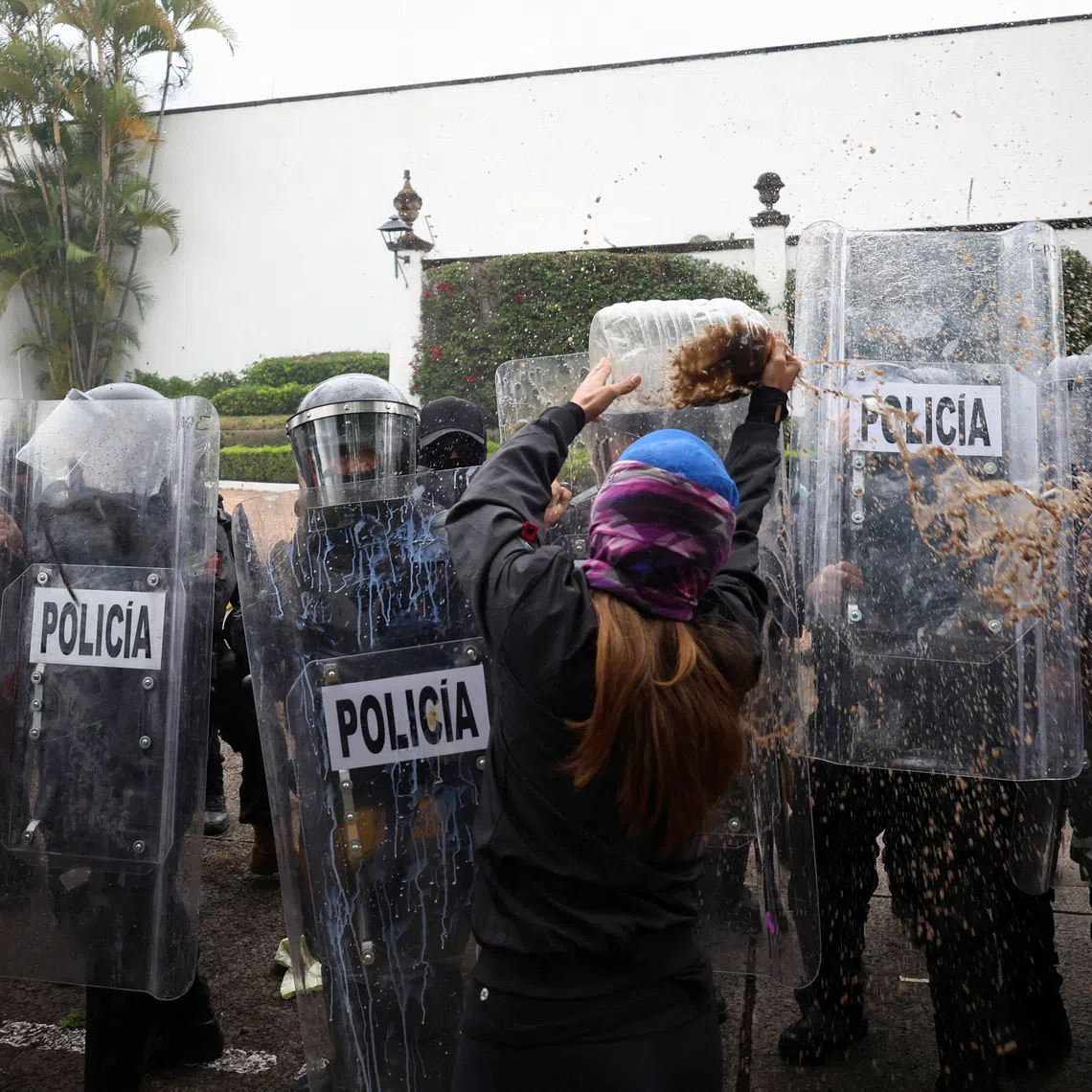 A protester throws dirty water at state riot police during a demonstration demanding clean water after weeks of residents' complaints about discolored and foul-smelling water in parts of the metropolitan area, outside Casa Jalisco, the official residence of the state governor, in Guadalajara, Mexico, October 11, 2026. REUTERS/Stringer