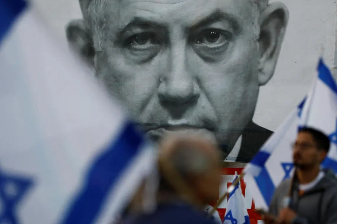 Protesters hold Israeli flags during a demonstration against Israeli Prime Minister Benjamin Netanyahu and his judicial overhaul, in Tel Aviv.