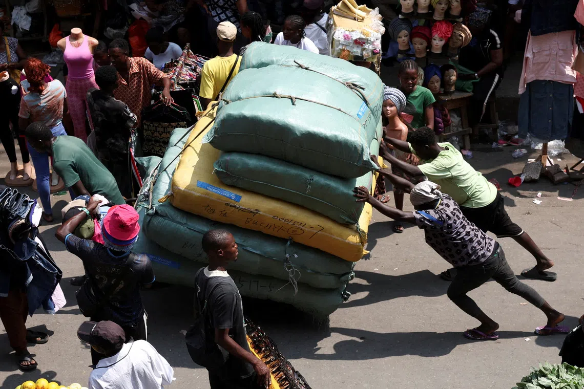 FILE PHOTO: People push a cargo cart through Balogun Market in the Marina business district of Lagos, Nigeria, December 2, 2025. REUTERS/Sodiq Adelakun/File Photo