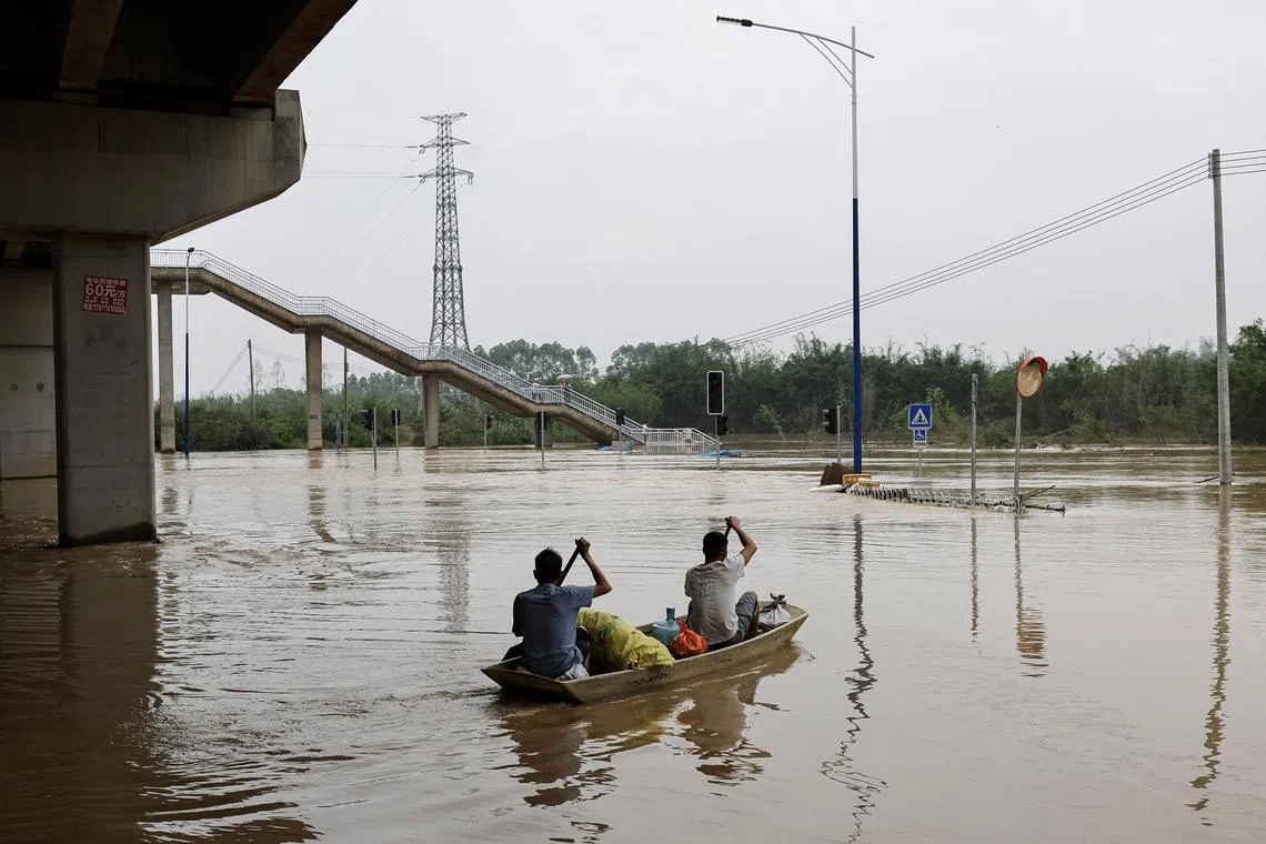 Residents rowing a boat on floodwaters, following heavy rainfall at Xiashahe village, Guangdong province, on April 22, 2024. 