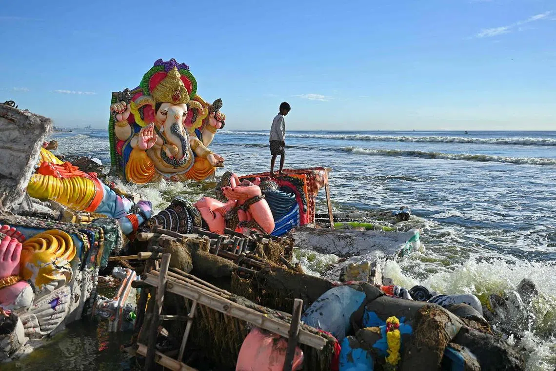 A boy stands next to the remains of idols of the Hindu deity Ganesha after they were immersed by devotees in the Bay of Bengal during the 'Ganesh Chaturthi' festival in Chennai on Sept 25.