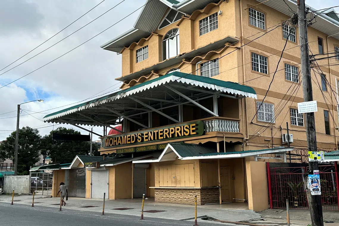 FILE PHOTO: A man passes by Mohamed's Enterprise office in Georgetown, Guyana, June 29, 2023. REUTERS/Sabrina Valle/File Photo