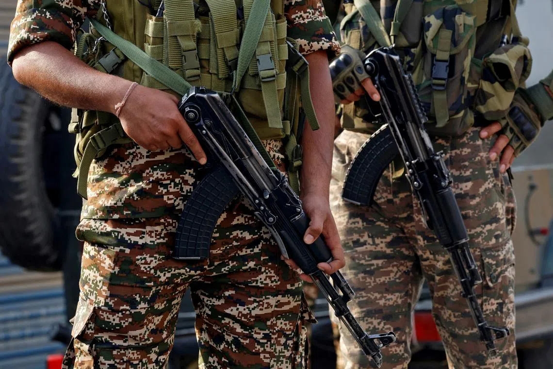 Indian security force personnel stand guard near the site of a fighter jet crash in Wuyan in India-administered Kashmir's Pulwama district May 7, 2025. REUTERS/Sharafat Ali