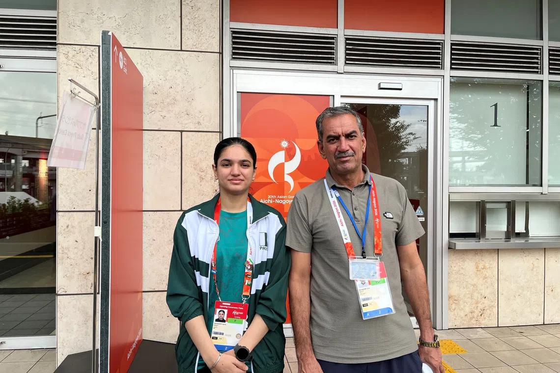 Asian Games - Aichi-Nagoya 2026 - Squash - Nagoya Kinjo Futo Arena, Nagoya, Japan - September 23, 2026 Pakistan squash player Sana Bahadar and her father Sher Bahadar pose for a picture outside the Nagoya Kinjo-Futo Arena REUTERS/Amlan Chakraborty