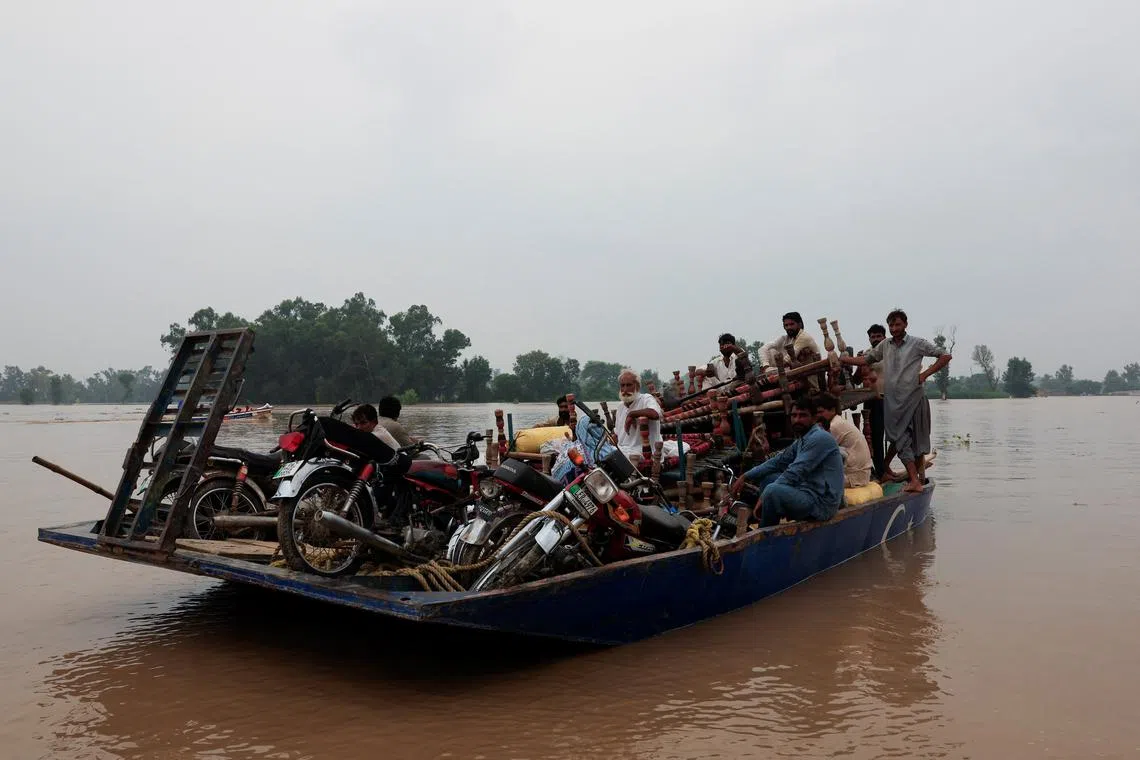 Residents heading towards higher ground, following monsoon rains and rising water level of the Sutlej River, near the Pakistan-India border, on Aug 29.