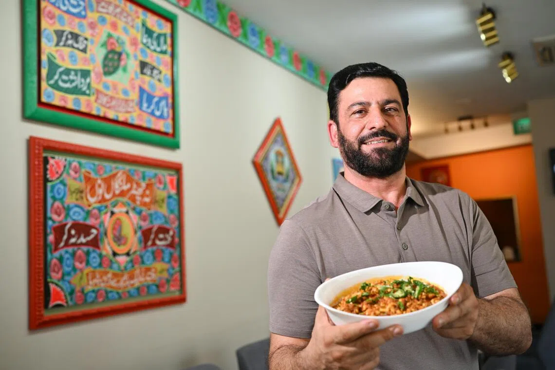Bar B Q Tonight restaurant manager Zakir Khan, 42, holding a dish of brain masala made up of goat brain stir fried with tomatoes, browned onions, spices and green chillies costs $20, inside the restaurant on Sept 3, 2026. 

(ST PHOTO: LIM YAOHUI)