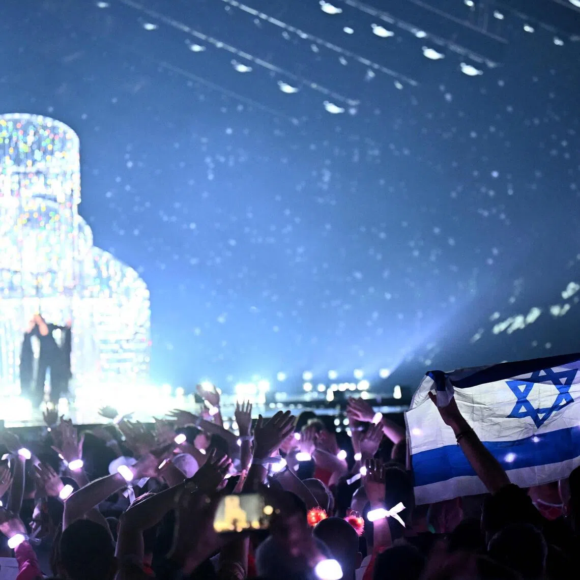 A member of the audience waving Israel's national flag as Israeli singer Yuval Raphael performs during the Eurovision Song Contest in Basel, Switzerland, in May 2025.