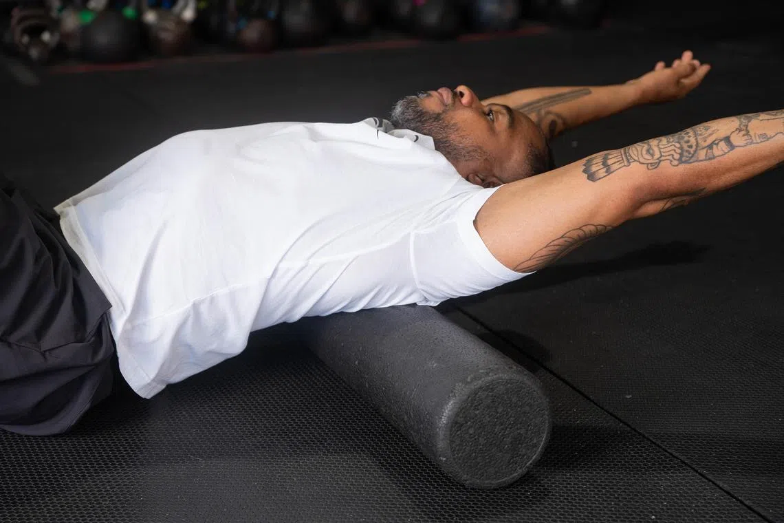 A back roll during a workout in New York, June 30, 2022. Low-impact active recovery offers relief for sore muscles and can restore your energy, research has found. 