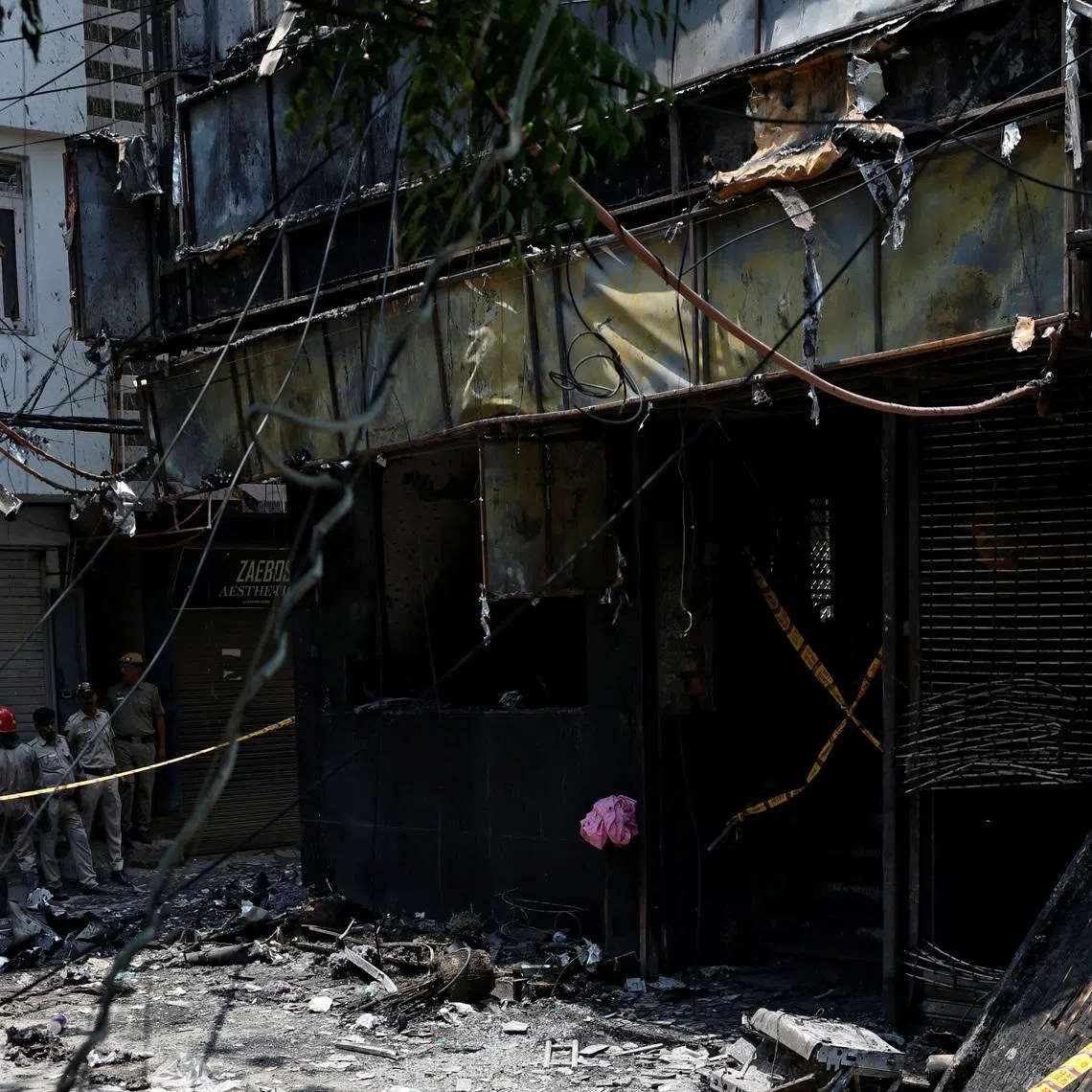 Firefighters and police officers work at the site after a fire at a hotel in New Delhi on June 3.