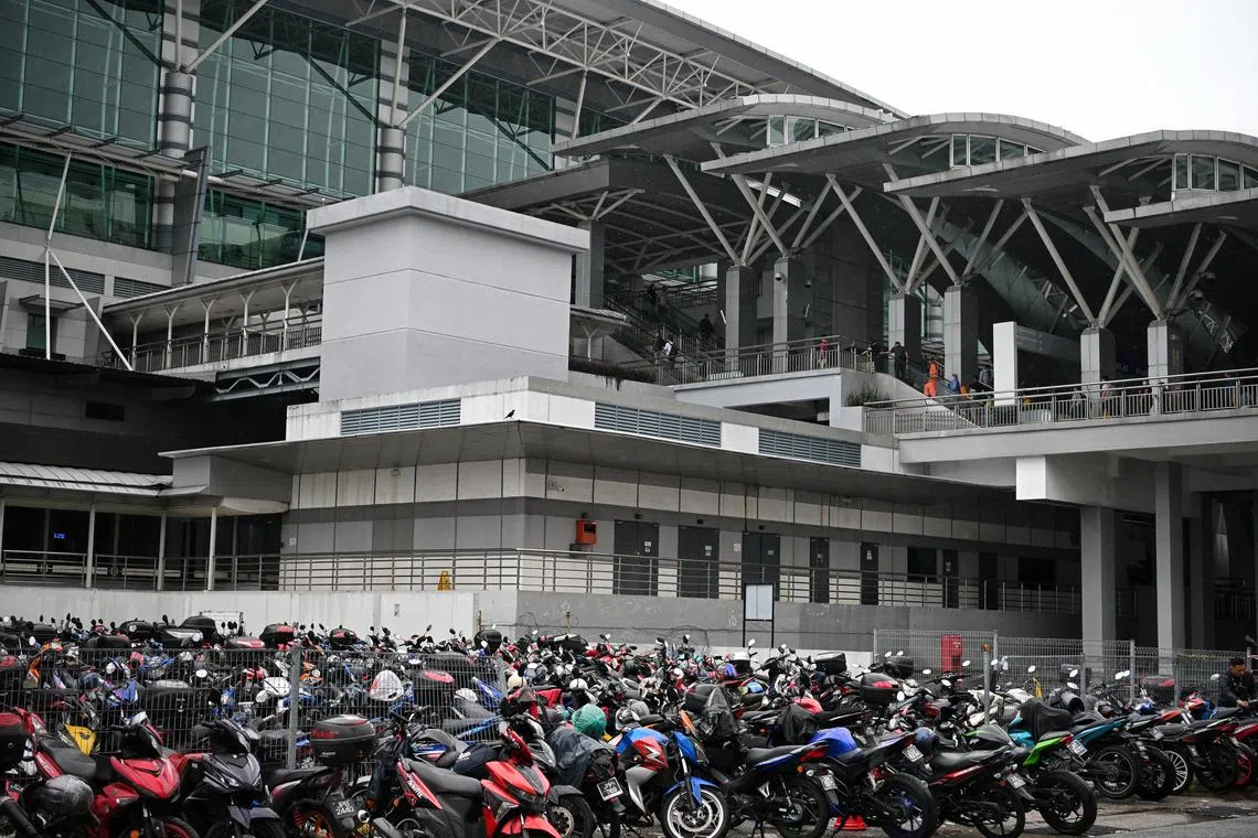 Motorcycles parked at the Bangunan Sultan Iskandar (BSI) Customs Immigration and Quarantine (CIQ) complex in Johor, Malaysia.