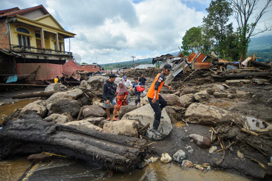 Locals walk in an area affected by heavy rain brought flash floods and landslides as they are evacuated in Agam, West Sumatra province, Indonesia, May 12, 2024, in this photo taken by Antara Foto. Antara Foto/Iggo El Fitra/via REUTERS