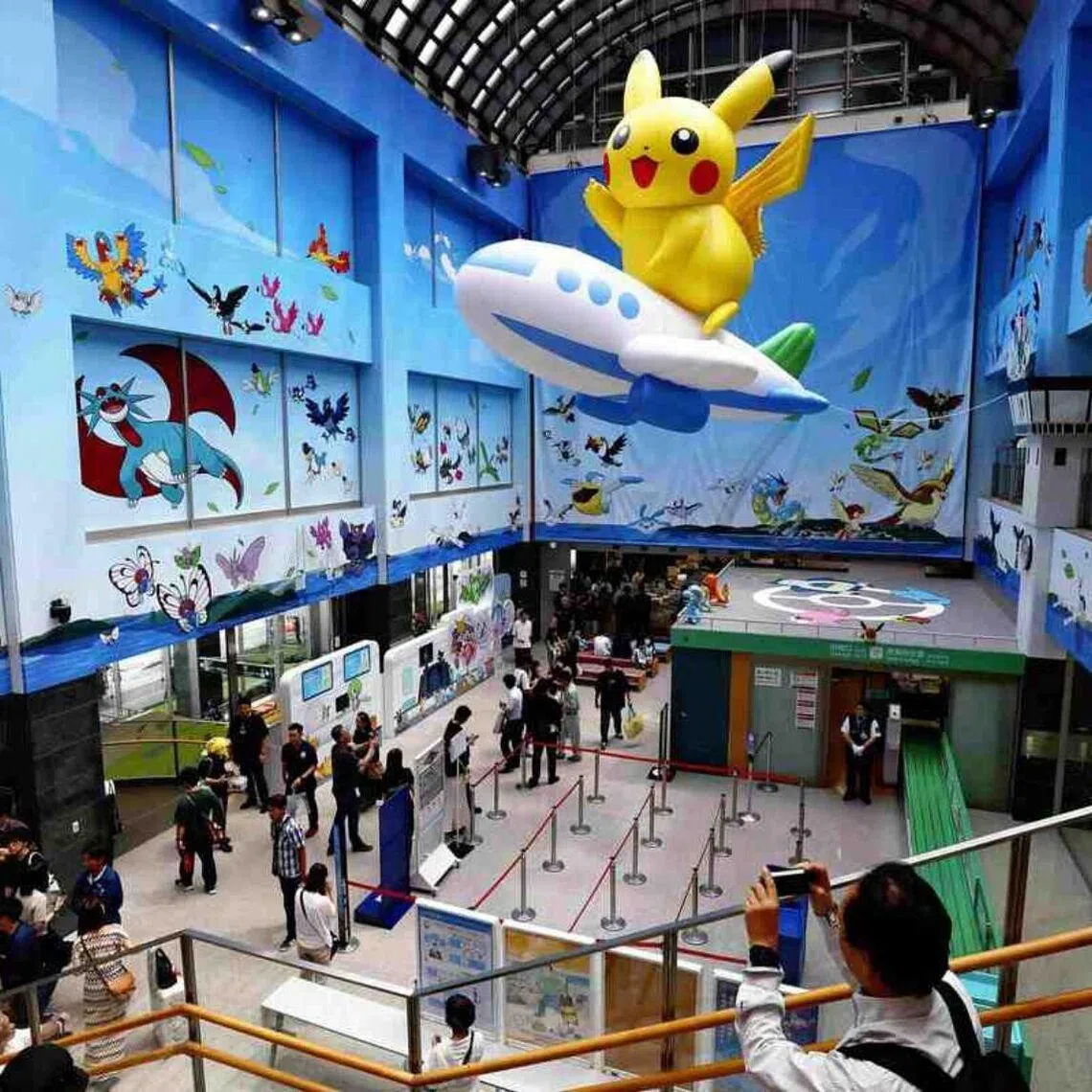 Inside the terminal, a giant Pikachu riding a balloon airplane is suspended from the atrium ceiling.