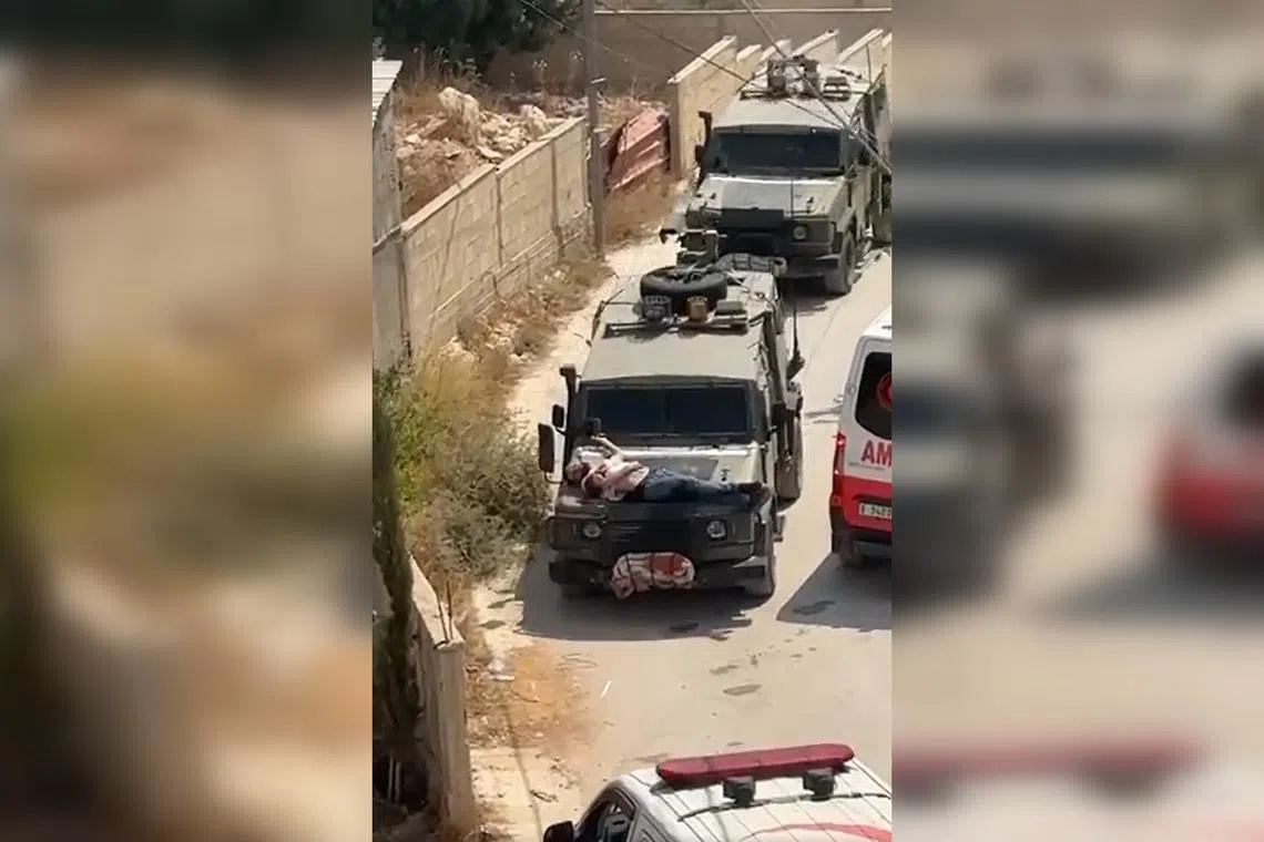 A video circulating on social media and verified by Reuters shows a Palestinian resident of Jenin, Mr Mujahed Azmi, on the jeep, which passes two ambulances.