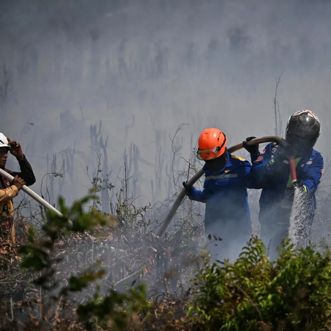 A group of firefighters putting out a fire in Banjarbaru, South Kalimantan, Indonesia, on Sep 13.