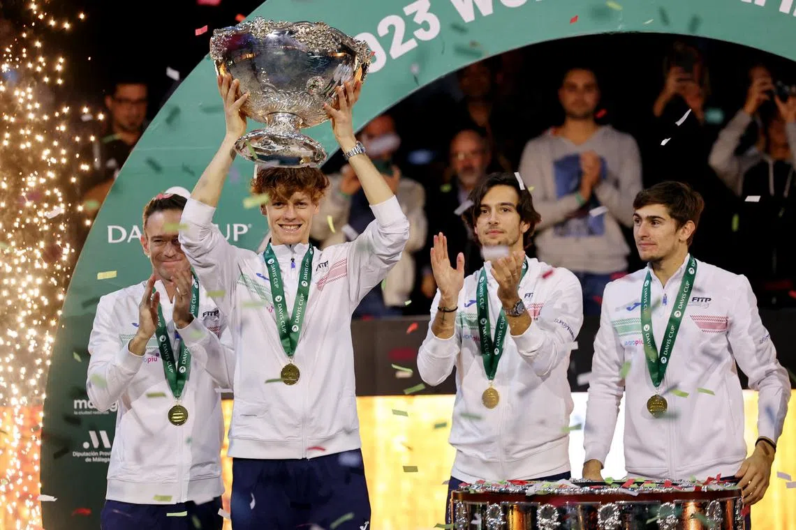 Italy's Jannik Sinner celebrates with the trophy and teammates after winning the Davis Cup.