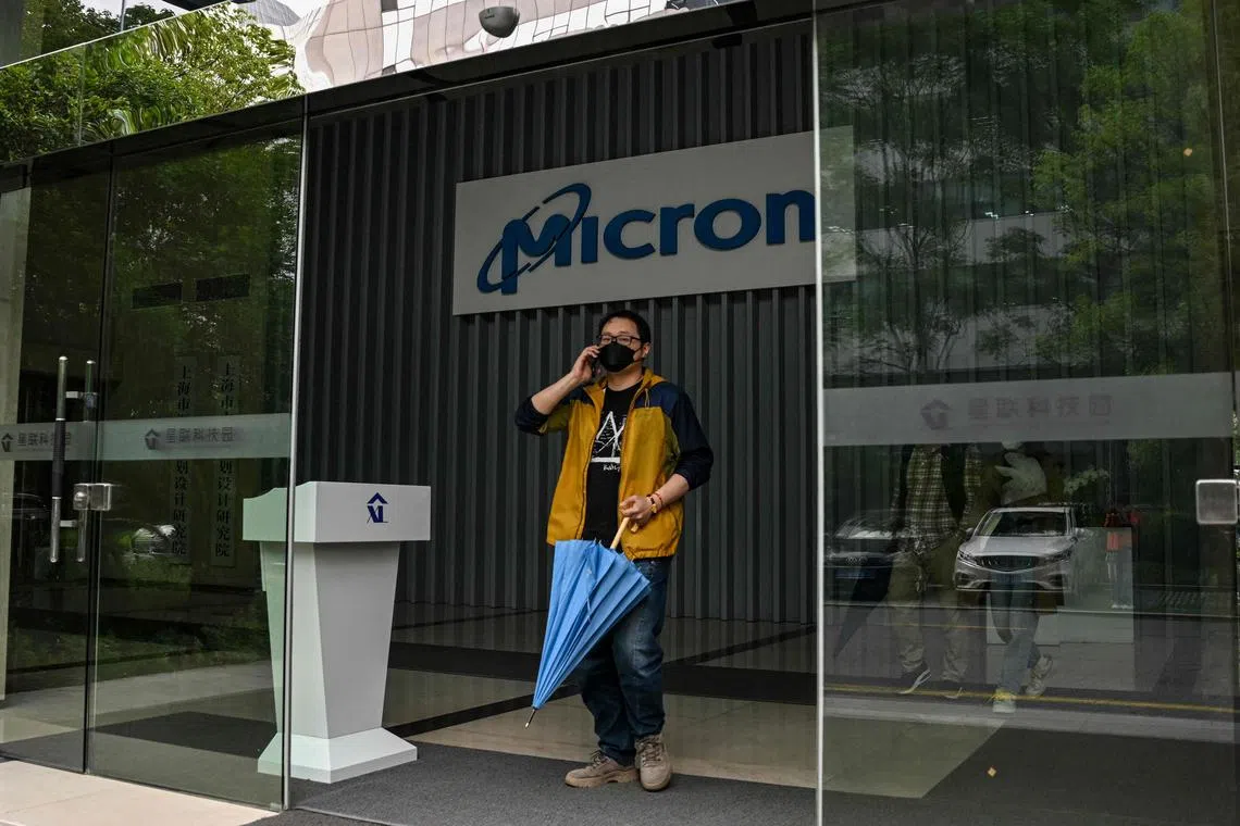 A person walks out of a building where the facilities of US semiconductor giant Micron is located in Shanghai on May 22, 2023. US semiconductor giant Micron has failed a national security review, China's cybersecurity watchdog said on May 21, telling operators of "critical information infrastructure" to stop buying its products. (Photo by Hector RETAMAL / AFP)