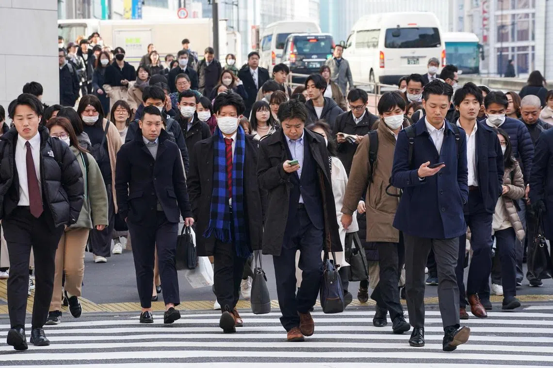 CORRECTION / People commuting to work in the morning cross a pedestrian crossing in Tokyo on February 15, 2024. (Photo by Kazuhiro NOGI / AFP) / “The erroneous mention appearing in the Byline of this photo has been modified in AFP systems in the following manner: [Kazuhiro NOGI] instead of [STR]. Please immediately remove the erroneous mention from all your online services and delete it from your servers. If you have been authorized by AFP to distribute it to third parties, please ensure that the same actions are carried out by them. Failure to promptly comply with these instructions will entail liability on your part for any continued or post notification usage. Therefore we thank you very much for all your attention and prompt action. We are sorry for the inconvenience this notification may cause and remain at your disposal for any further information you may require.”