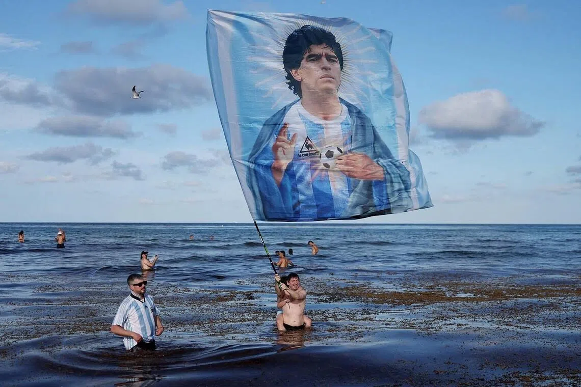 Soccer Football - FIFA World Cup 2026 - Argentina fans gather in Miami - Miami, Florida, U.S. - July 2, 2026 Argentina fans stand in the sea with a flag of Diego Maradona as they gather in Miami ahead of their Round of 32 match tomorrow against Cape Verde REUTERS/Amanda Perobelli TPX IMAGES OF THE DAY
