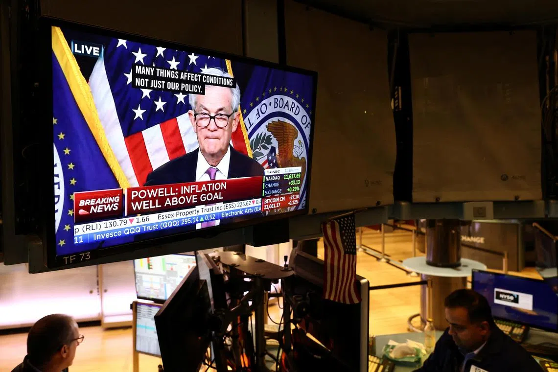 Traders work on the floor of the New York Stock Exchange, as a screen shows Federal Reserve  chairman Jerome Powell during a news conference.