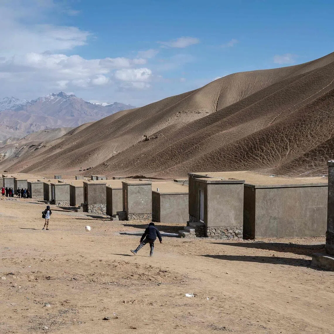 Children playing football near the newly constructed houses for Afghan returnees from Iran and Pakistan in Jar-e-Khushk on the outskirts of Bamiyan province.  