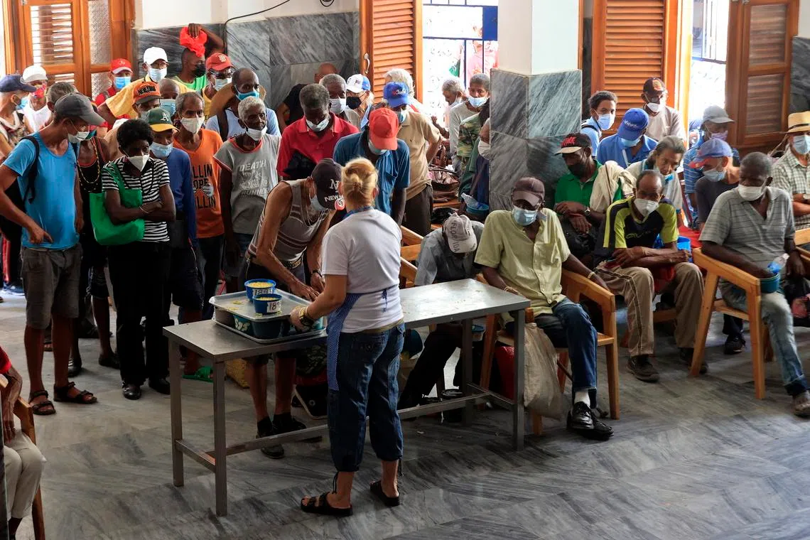 People receive food from staff of the NGO Quisicuaba in Havana on May 25. Experts say instability in Cuba threatens a migration crisis.