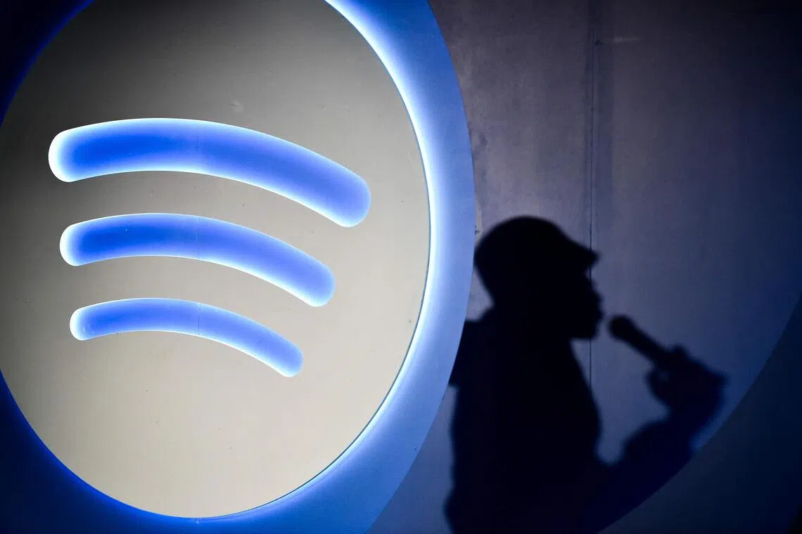 (FILES) Spotify's Artificial Intelligence DJ announcer, Xavier X Jernigan's shadow, is pictured as he attends the presentation of the latest Spotify tool in Mexico City on July 17, 2024. A rising tide of artificial intelligence (AI) bands is ushering in a new era where work will be scarcer for musicians. Whether it's Velvet Sundown's 1970s-style rock or country music projects "Aventhis" and "The Devil Inside," bands whose members are pure AI creations are seeing more than a million plays on streaming giant Spotify. (Photo by Rodrigo Oropeza / AFP)