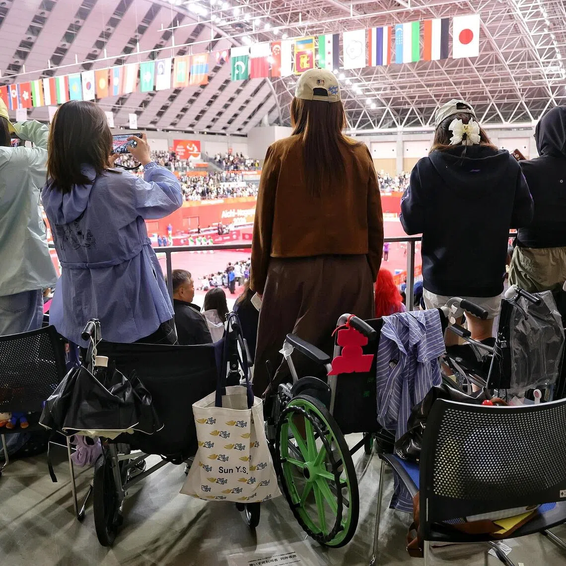 A group of Chinese table tennis fans standing up from their wheelchairs for China’s national anthem during the Aichi-Nagoya Asian Games table tennis women’s doubles and men’s singles finals on Sept 28.